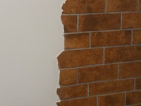 Immitation von einer verklinkerten Wand mit braunroten Klinkern.